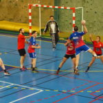 Joueur de handball loisirs en ufolep qui est en train de tirer en suspension pour marquer.